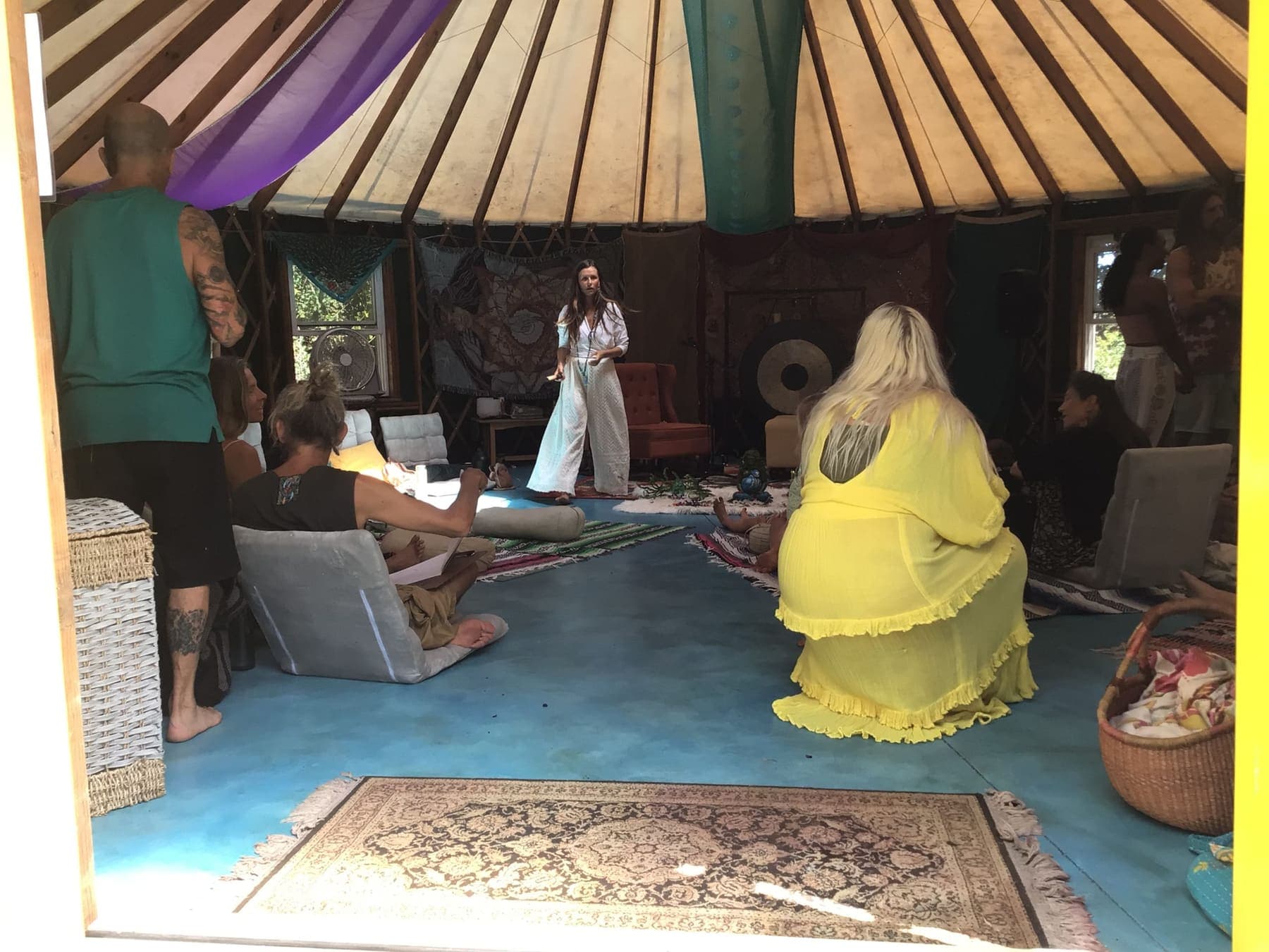 A gathering inside the yurt on its ocean blue floor